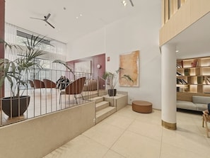 A modern interior with a staircase, seating area, and a bookshelf. - Studio Apartment Adapted for People with Limited Mobility · Retiro (Madrid)