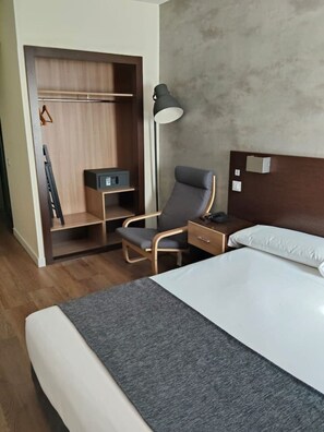 A hotel room with a bed, a desk, a chair, a wardrobe, and a floor lamp. - Studio Apartment Adapted for People with Limited Mobility · Retiro (Madrid)