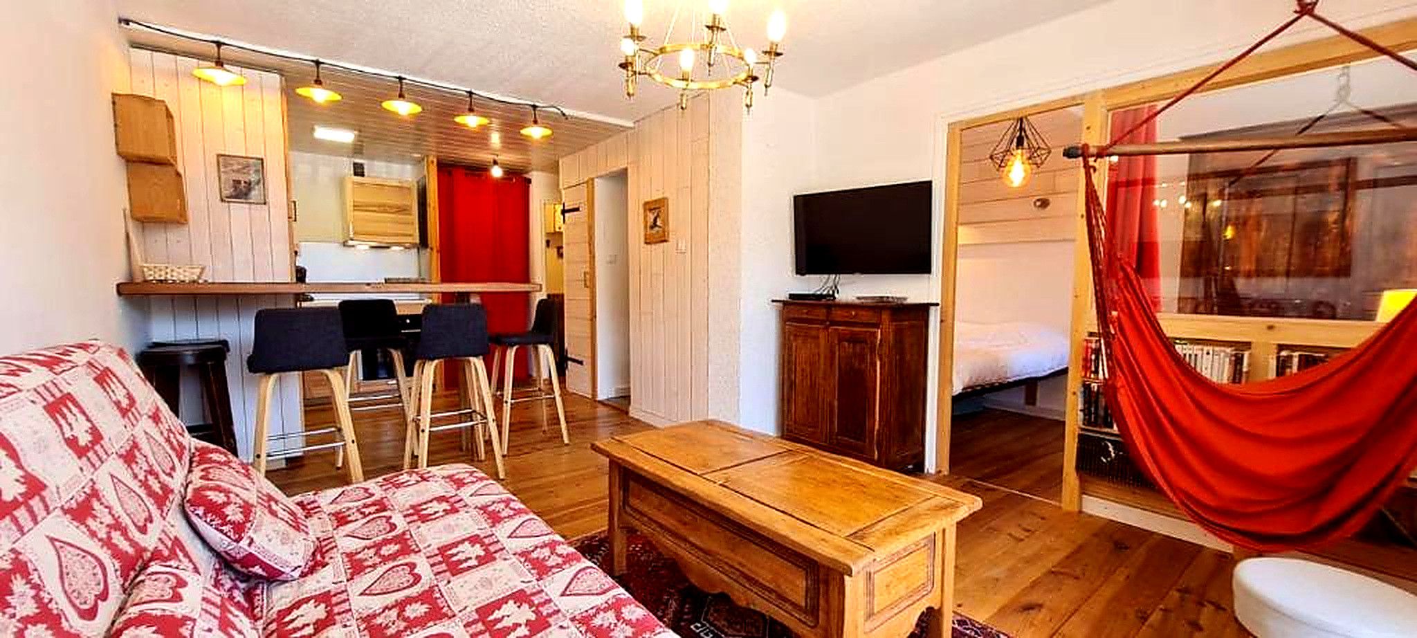 Un salon chaleureux avec un canapé, une table basse en bois et un coin repas avec des chaises.
