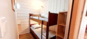 A bunk bed room with wooden walls and a door. - Charming apartment for 6 people with a mountain view (Les Deux Alpes)