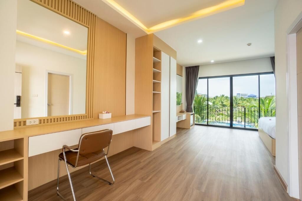A modern bedroom with a large window, a built-in desk, and a chair.