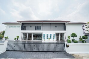 A two-story building with a modern design, featuring a large glass entrance and a metal gate at the front. - PP Garden Home (Bangkok)