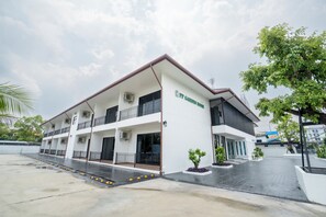 A multi-story building with a flat roof, air conditioning units, and a sign that reads 'PP Garden Home'. - PP Garden Home (Bangkok)