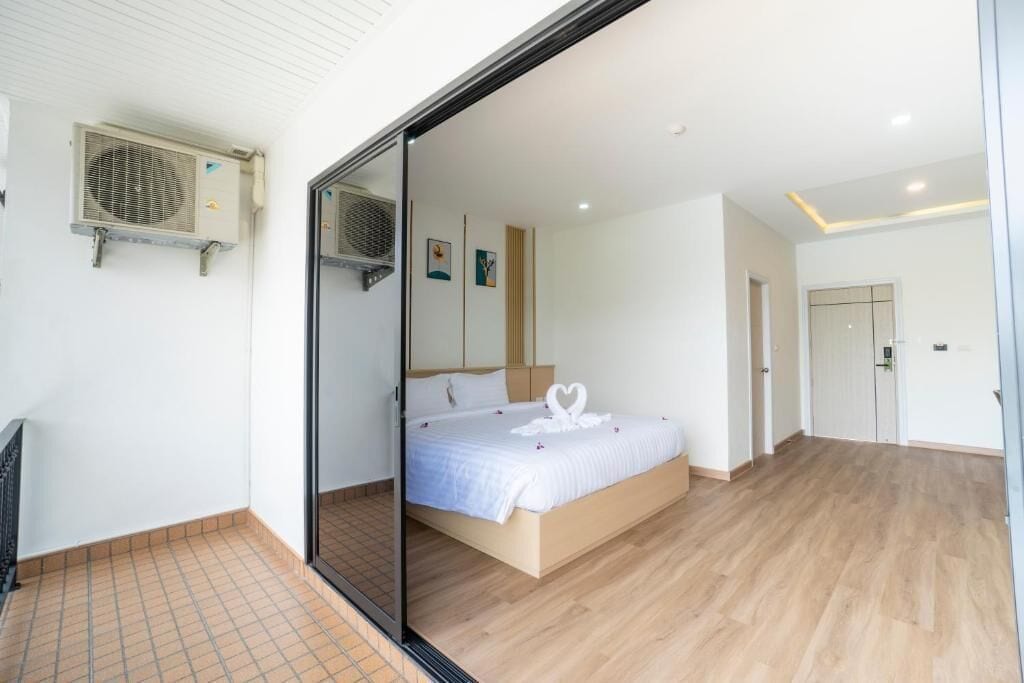 Un dormitorio moderno con una cama grande, una puerta corredera y un ventilador de techo.