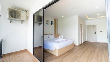 Un dormitorio moderno con una cama grande, una puerta corredera y un ventilador de techo.