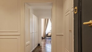 A hallway with white panel doors, a dark door on the right, and a patterned floor. - Casa Dolce Roma – Your home in the heart of Rome! (Roma)