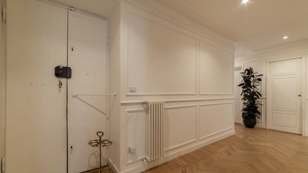 A hallway with white walls, a radiator, and a potted plant. - Casa Dolce Roma – Your home in the heart of Rome! (Roma)
