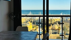 Una habitación con vista al mar, una mesa y una silla.