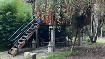 A wooden staircase leading to a covered area with benches and a lantern.