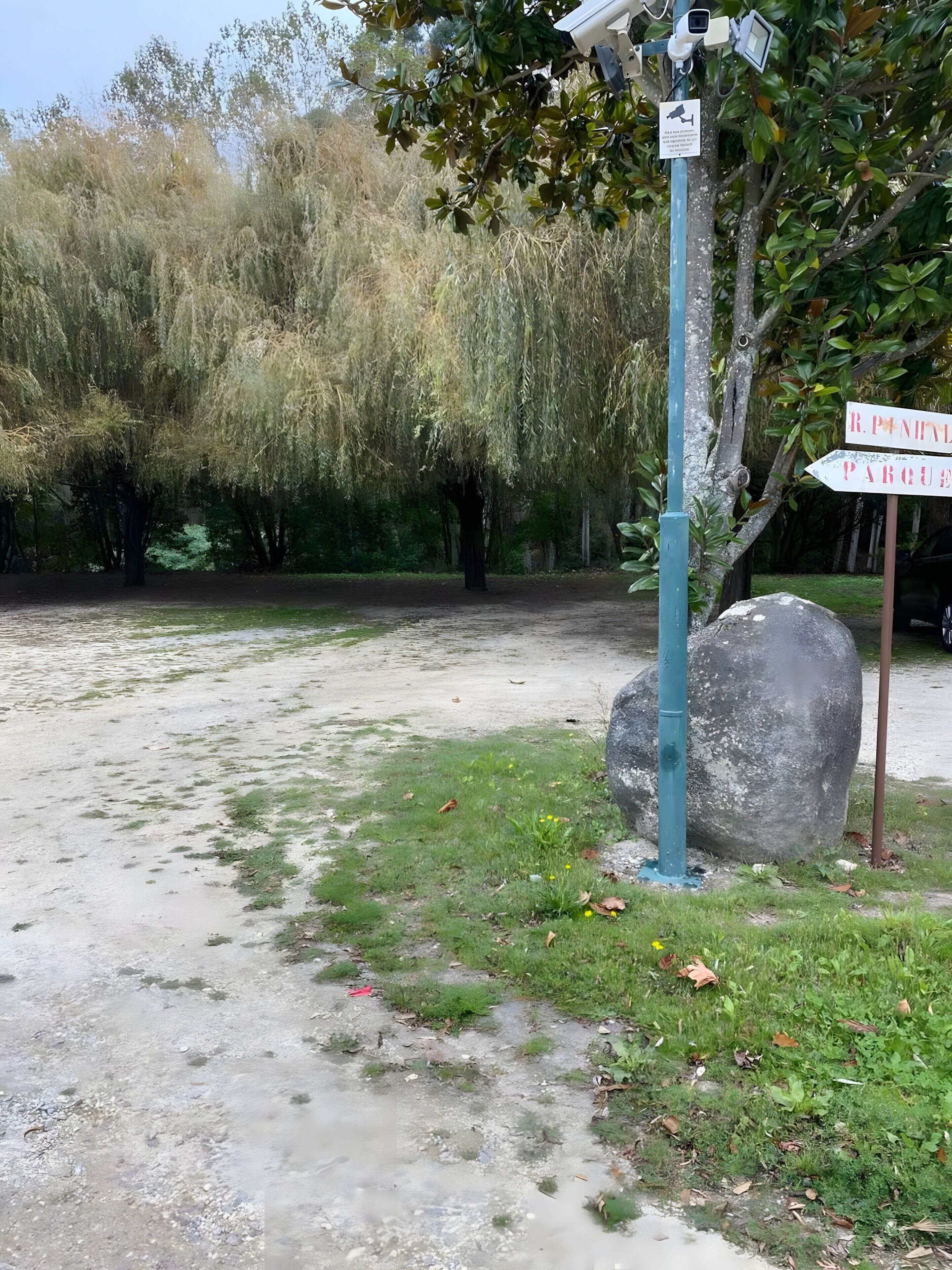 A gravel path with a signpost indicating directions to R.P. Nival and Parque.