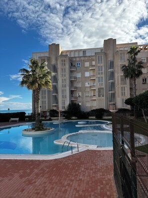 Ein Hotel mit Schwimmbad, Palmen und Blick auf den Ozean.