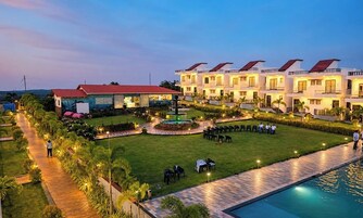 Un hotel con varias edificaciones, piscina y un jardín bien cuidado.