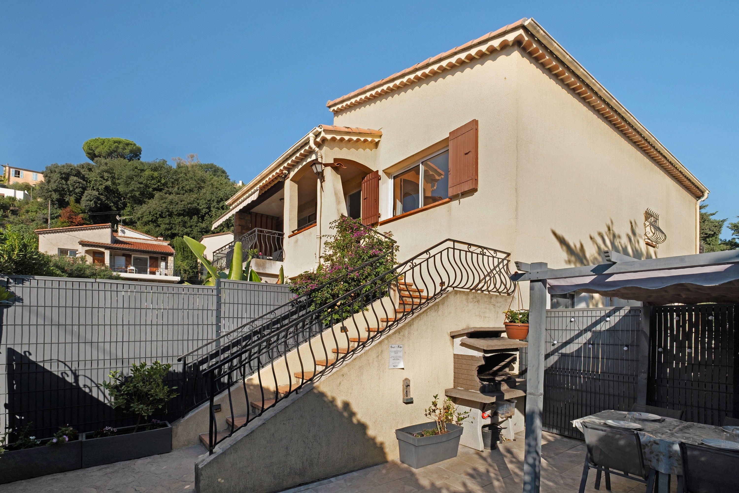A two-story building with a balcony and a staircase leading to the entrance.