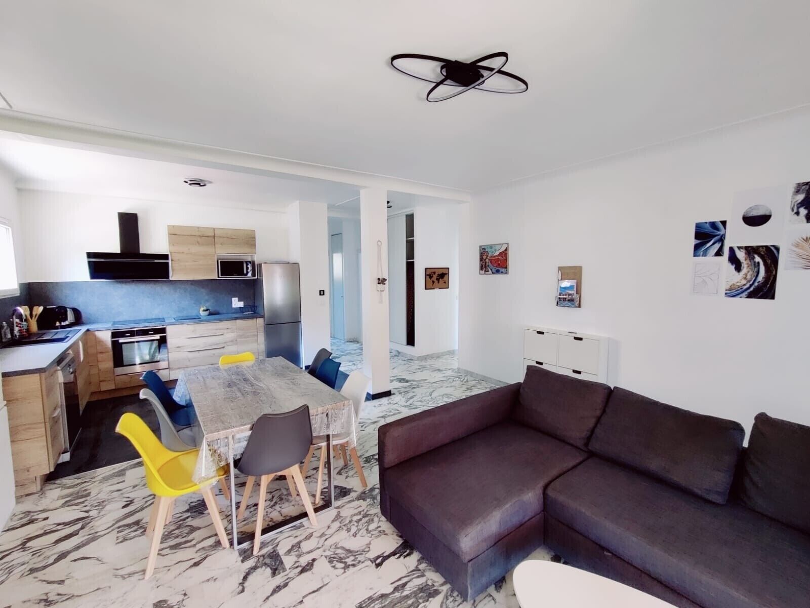 A modern living space with a kitchen, dining area, and seating area.