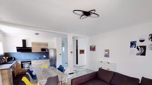 Ein modernes Wohnzimmer mit Küche, Essbereich und Sitzgelegenheit.
