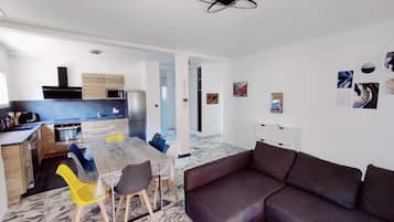 A modern living space with a kitchen, dining area, and seating area.