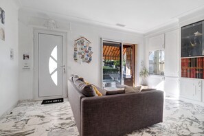 A living room with a sofa, a coffee table, and a bookshelf. - Villa "Upper" – 3 bedrooms, 8 guests, private terrace, Wi-Fi, air conditioning (Cagnes-sur-Mer)