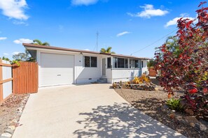 A single-story house with a garage, a front porch, and a small garden with red-leafed plants. - Ideal for Tradies. BBQ, WiFi, Pet friendly (Torquay)