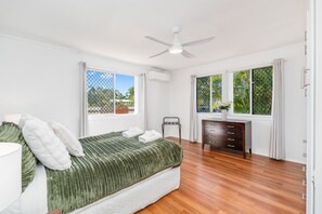 A bedroom with a bed, a desk, a chair, and two windows. - Ideal for Tradies. BBQ, WiFi, Pet friendly (Torquay)