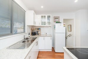 Eine kleine Küche mit Spüle, Arbeitsplatte und Kühlschrank.