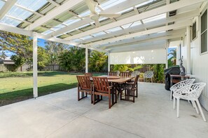 A covered patio with a table and chairs, a grill, and a view of the backyard. - Ideal for Tradies. BBQ, WiFi, Pet friendly (Torquay)