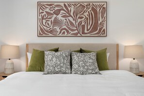 A bedroom with a bed, pillows, a headboard, and a wall-mounted artwork. - Disney, Heated Pool, Game Rm, Fire Pit, King Bed- Getaway Retreat (Hacienda Heights)