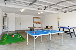 A room with a ping pong table, a pool table, and a small indoor golf course setup. - Disney, Heated Pool, Game Rm, Fire Pit, King Bed- Getaway Retreat (Hacienda Heights)