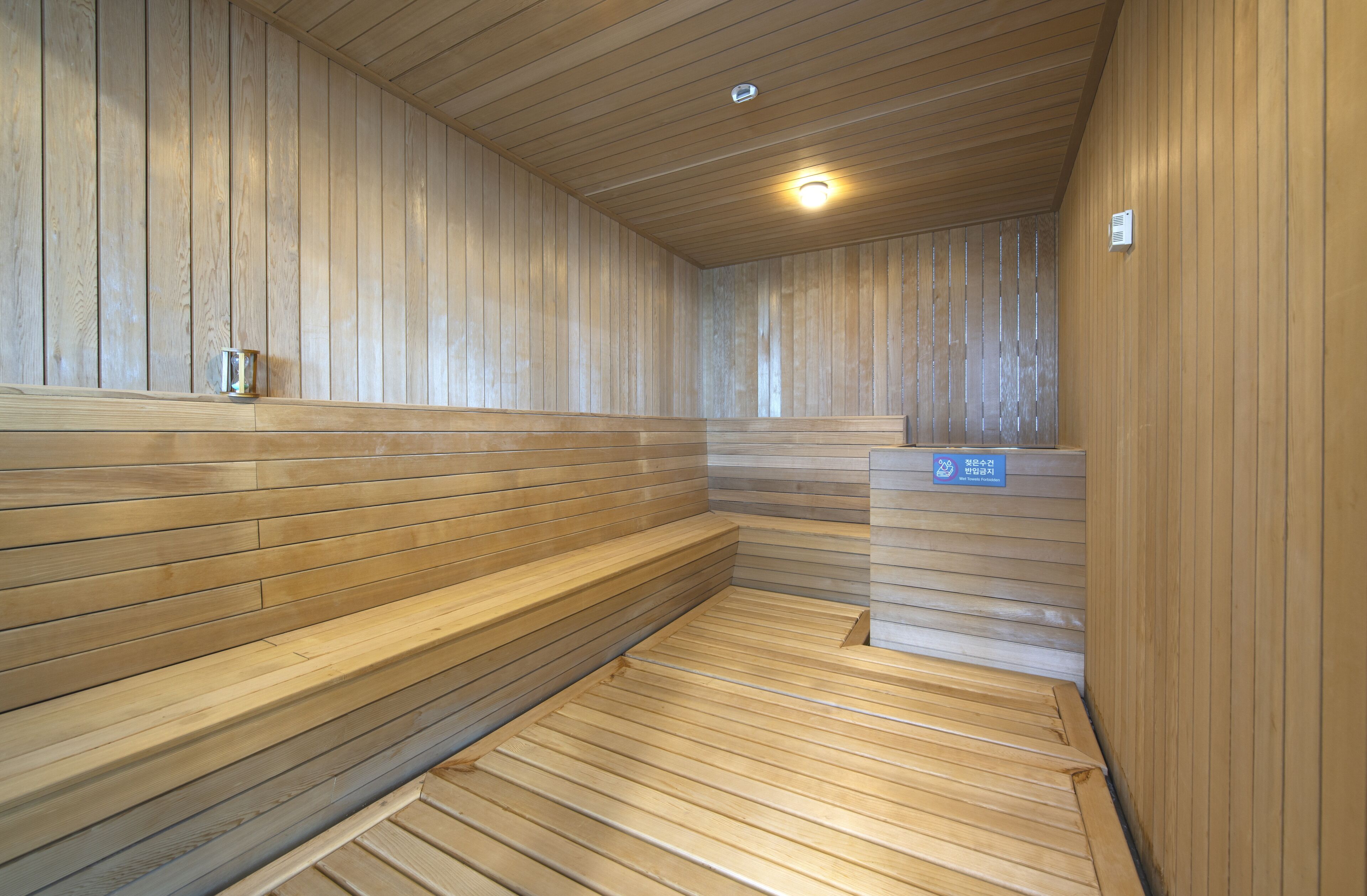 A sauna with wooden benches and a tiled floor.