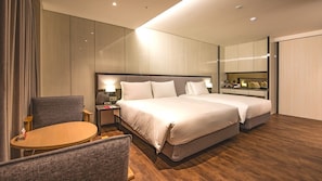 Habitación de hotel con una cama grande, un escritorio, una silla y un espejo.