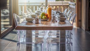 A dining area with a wooden table, clear chairs, and a fruit bowl. - Chalet 1907 (Gérardmer)