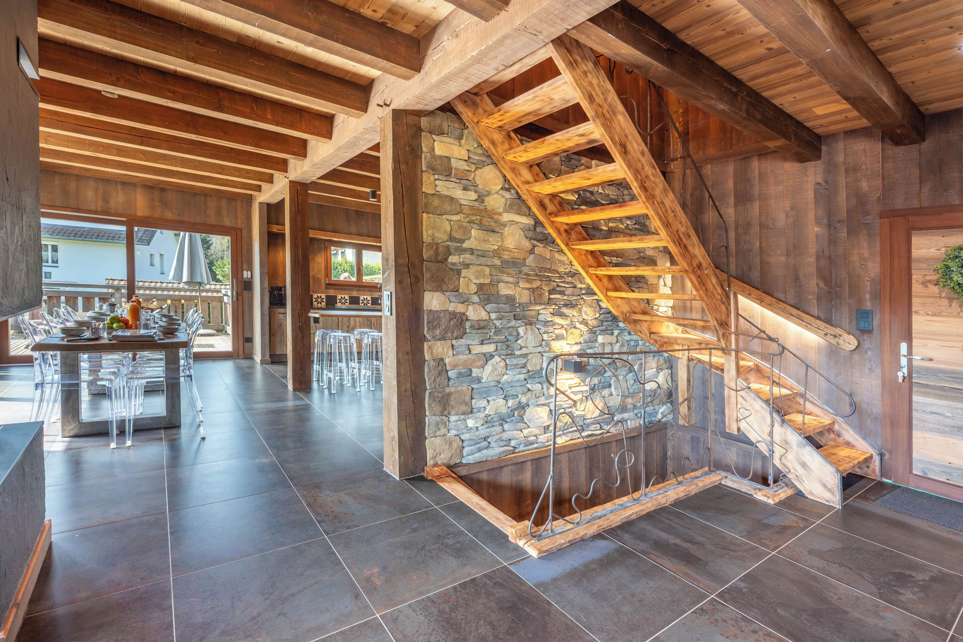 Un intérieur spacieux avec un mur en pierre et un escalier en bois.