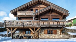 A two-story wooden chalet with a balcony, stone foundation, and a stone fireplace. - Chalet 1907 (Gérardmer)
