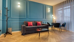 Deluxe-Apartment, Balkon, Stadtblick | Wohnbereich | 50-Zoll-Smart-TV mit Kabelempfang