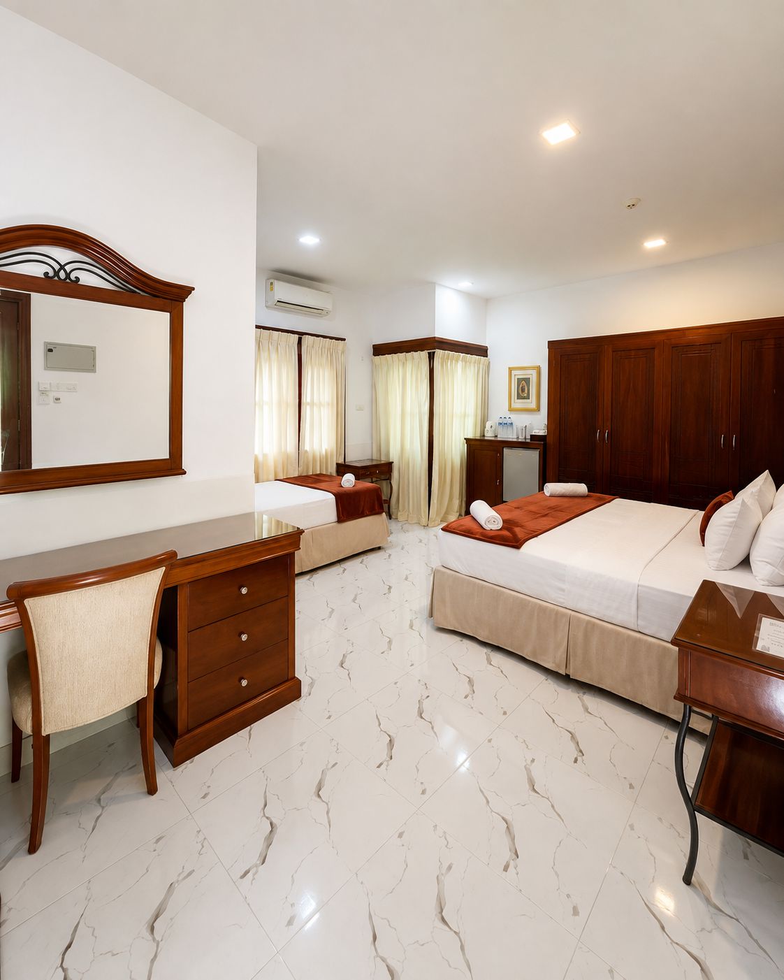A hotel room with a bed, a desk, a chair, a wardrobe, and a bathroom.