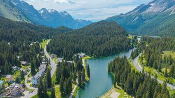 Un paysage montagneux avec une rivière, des routes et des bâtiments.