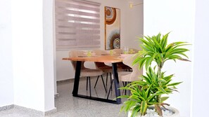 Un coin repas avec une table en bois, des chaises et une plante en pot.
