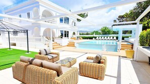 A poolside area with wicker furniture and a clear view of a swimming pool. - Villa Cecilia Coral - Beautiful Mansion in Coral Bay (Coral Bay)