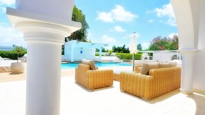 A poolside area with wicker furniture and a clear view of the pool. - Villa Cecilia Coral - Beautiful Mansion in Coral Bay (Coral Bay)