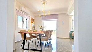 A dining area with a wooden table, chairs, and a chandelier. - Villa Cecilia Coral - Beautiful Mansion in Coral Bay (Coral Bay)