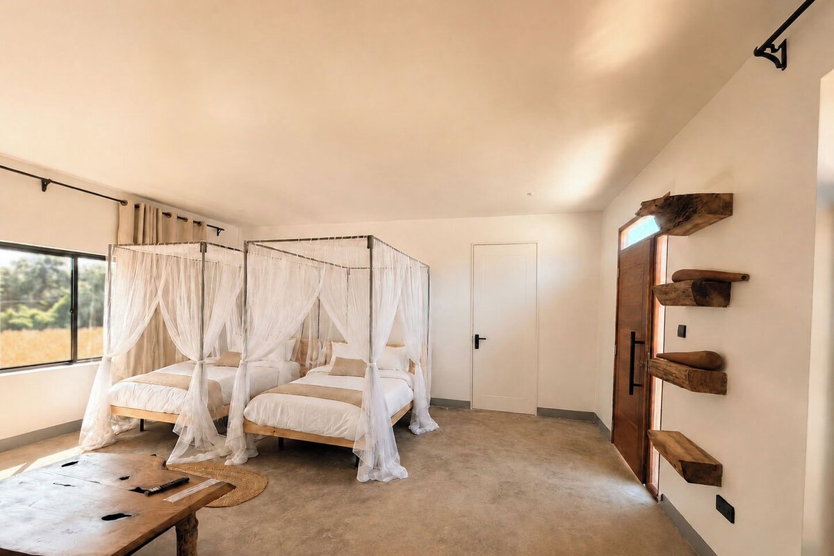 Une chambre à coucher avec un lit à baldaquin, une table de chevet en bois et une vue sur l’extérieur.