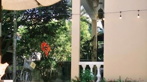Una piscina con vista despejada del agua, rodeada por un edificio con balcón y luces de adorno.