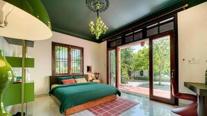 Un dormitorio con cama, escritorio, silla y vistas al exterior.