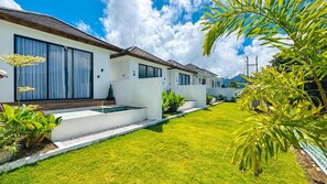 Una propiedad residencial moderna con un césped cuidado, piscina y cielo despejado.
