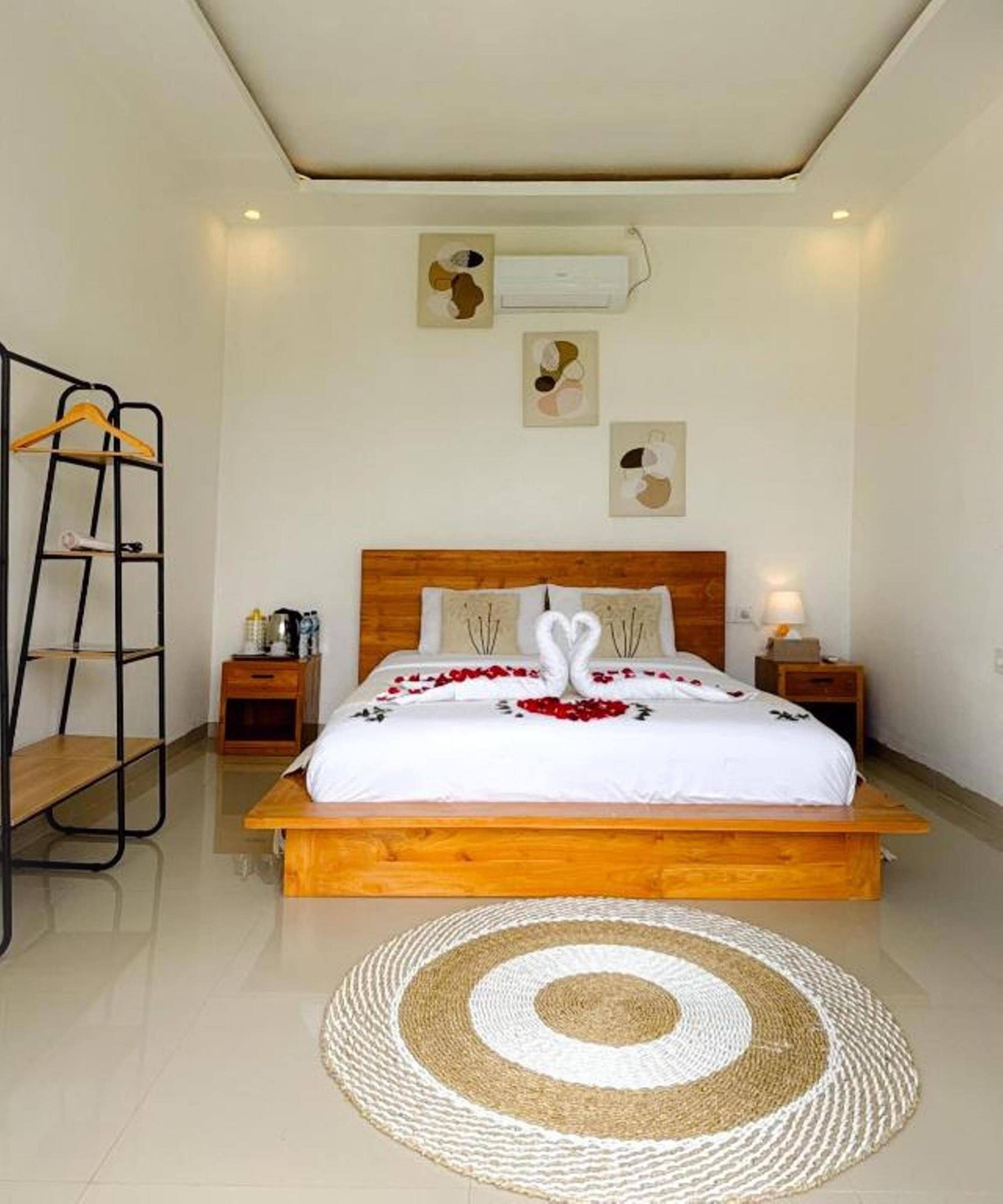 Un dormitorio con una cama de madera, un tapete redondo tejido y un aire acondicionado instalado en la pared.