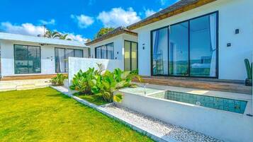 Una propiedad residencial moderna con un césped cuidado, piscina y ventanas amplias.