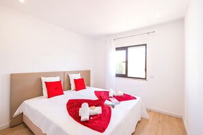 Hotellihuone, jossa on suuri sänky, ikkuna ja näkymä ulos.