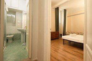 A bedroom with a wooden floor, a bed, a dresser, and a bathroom with a sink and bidet. - Welcome to this beautiful, newly renovated apartment, modern, spacious, and equipped with every comfort, located in Piazza Cavalleggeri, in an ideal location for exploring Florence on foot.The apartment is perfect for families, groups of friends, or anyo (Firenze)