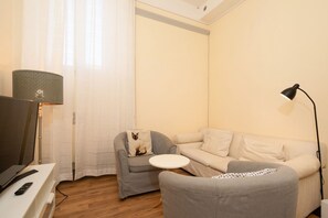 A living room with a sofa, a small armchair, a television, and a lamp. - Welcome to this beautiful, newly renovated apartment, modern, spacious, and equipped with every comfort, located in Piazza Cavalleggeri, in an ideal location for exploring Florence on foot.The apartment is perfect for families, groups of friends, or anyo (Firenze)