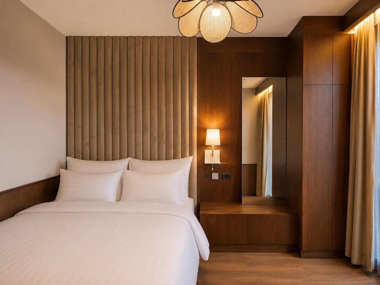 Ein Hotelzimmer mit einem großen Bett, einer Wandlampe und einem Spiegel.