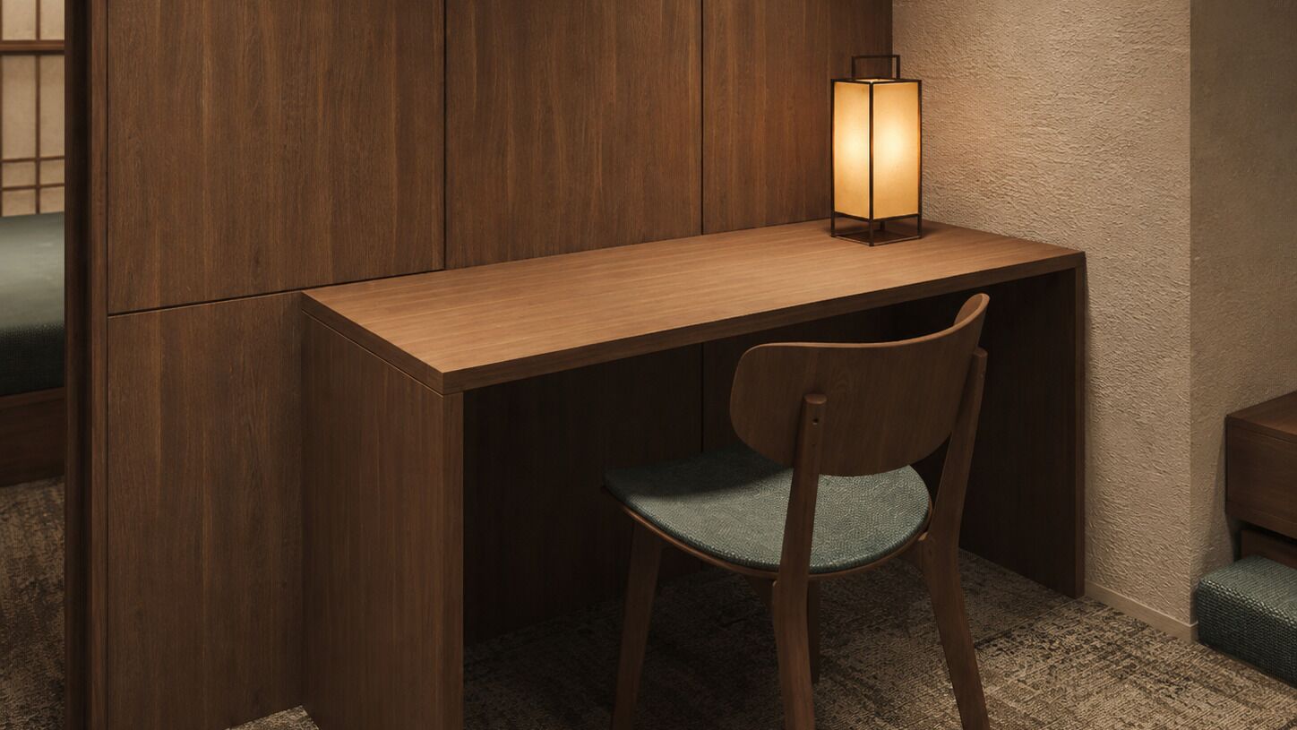 Een houten bureau met een stoel en een wandlamp.